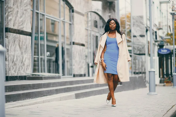 Bir sonbahar şehrinde duran siyah kadın