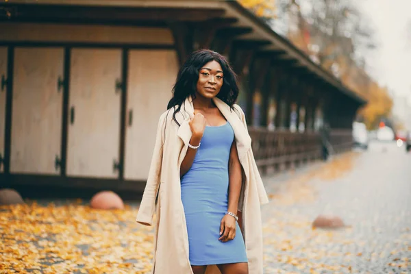 Bir sonbahar şehrinde yürüyen siyah kadın