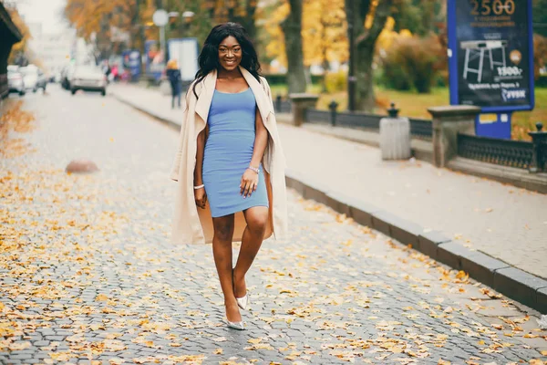 Bir sonbahar şehrinde yürüyen siyah kadın — Stok fotoğraf