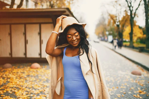 Bir sonbahar şehrinde yürüyen siyah kadın