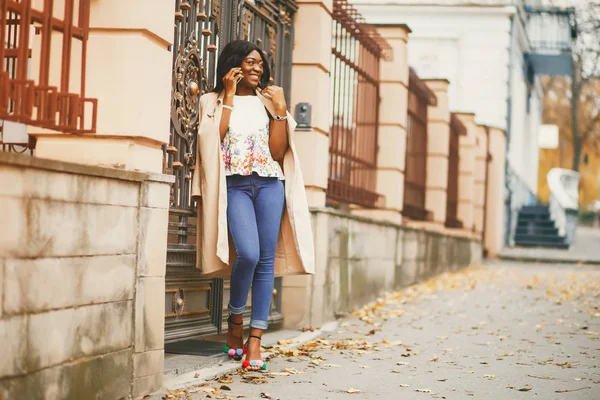 Mulher negra em pé em uma cidade de outono — Fotografia de Stock