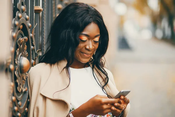 Bir sonbahar şehrinde duran siyah kadın