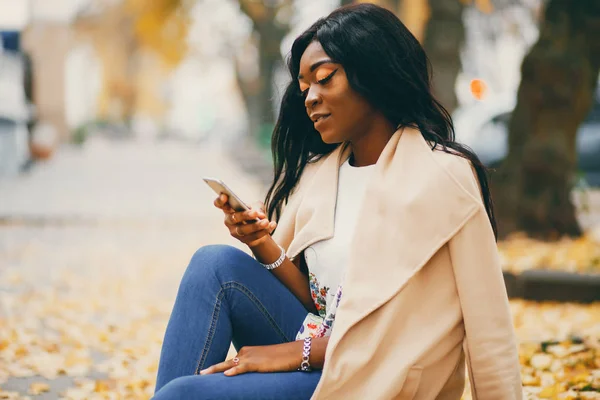 Bir sonbahar şehrinde oturan siyah kadın