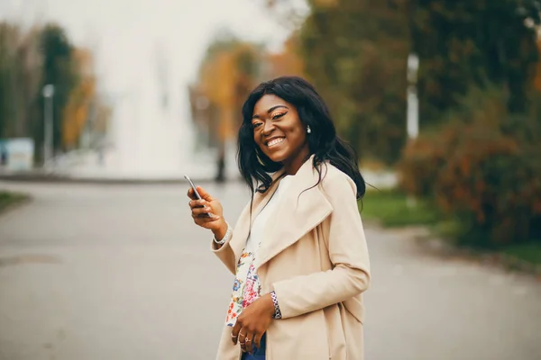 Mulher negra em pé em uma cidade de outono — Fotografia de Stock