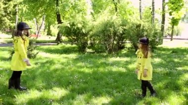 parkta birlikte oynayan iki kız kardeş