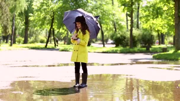Parkta bir su birikintisi oynayan çocuk video — Stok video