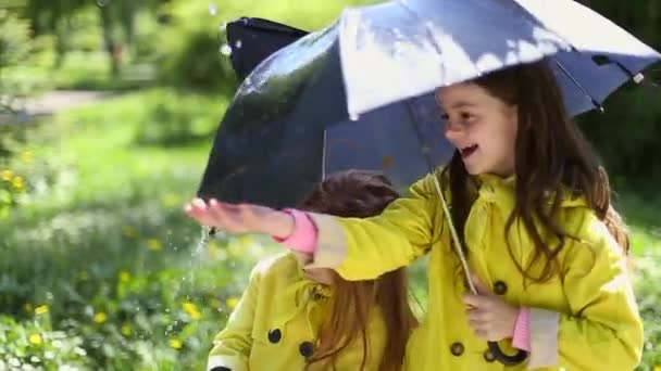 Młoda dziewczyna trzyma parasol i gra w deszczu — Wideo stockowe