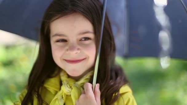 Fiatal lány kezében esernyő és játszik az esőben — Stock videók