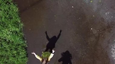 Parkta su birikintilerinde oynayan ve koşan iki kız