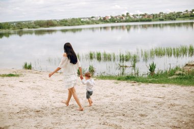 Anne ve oğlu yaz parkında oynuyorlar.
