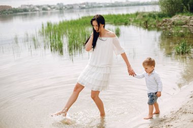 Anne ve oğlu yaz parkında oynuyorlar.