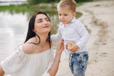 Anne ve oğlu yaz parkında oynuyorlar.