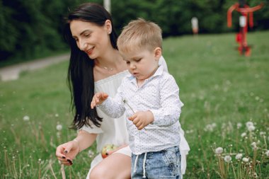 Anne ve oğlu yaz parkında oynuyorlar.