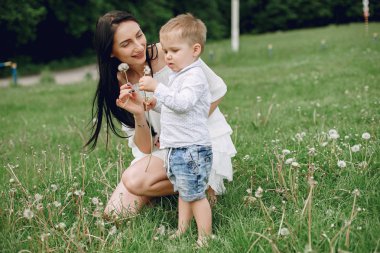 Anne ve oğlu yaz parkında oynuyorlar.