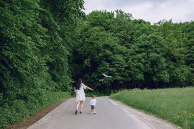 Anne ve oğlu yaz parkında oynuyorlar.