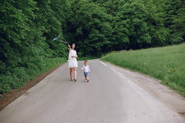 Anne ve oğlu yaz parkında oynuyorlar.