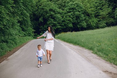 Anne ve oğlu yaz parkında oynuyorlar.