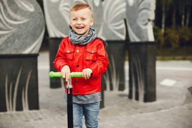 Bir parkta bir çim üzerinde oynayan sevimli çocuk