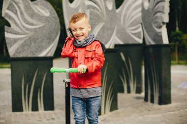 Bir parkta bir çim üzerinde oynayan sevimli çocuk