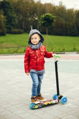 Bir parkta bir çim üzerinde oynayan sevimli çocuk