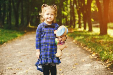 Bir parkta bir çim üzerinde oynayan sevimli çocuk