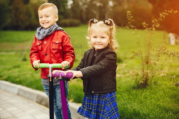 Criança bonito em um parque brincando em uma grama — Fotografia de Stock