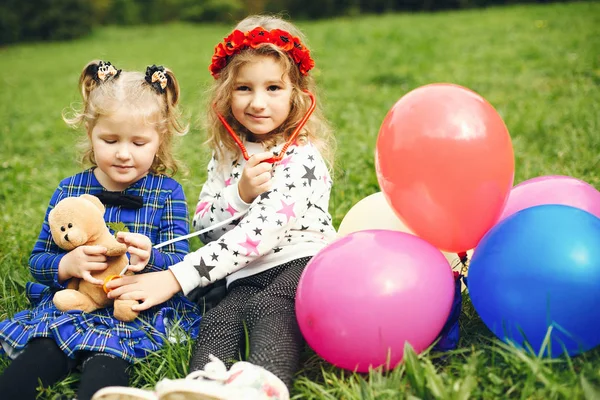 Criança bonito em um parque brincando em uma grama — Fotografia de Stock