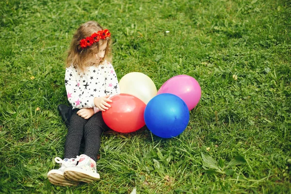 Χαριτωμένο παιδί σε ένα πάρκο παίζοντας σε ένα γρασίδι — Φωτογραφία Αρχείου