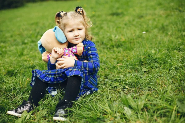 Söt barn i en Park som leker på ett gräs — Stockfoto