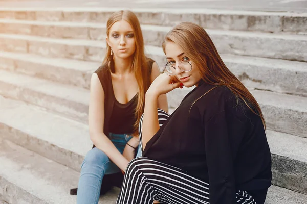 Chicas de moda sentadas en una ciudad de verano — Foto de Stock