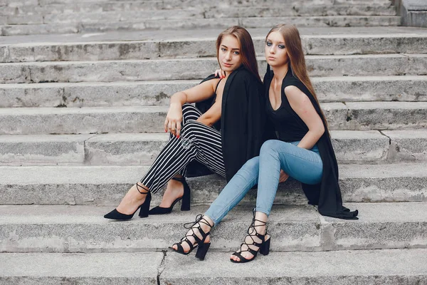 Девушки из моды сидят в летнем городе — стоковое фото