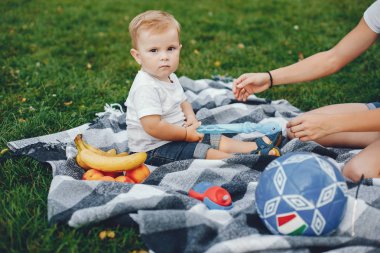 Anne ve oğlu yaz parkında oynuyorlar.