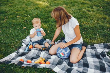 Anne ve oğlu yaz parkında oynuyorlar.
