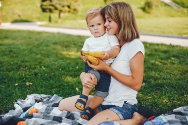 Anne ve oğlu yaz parkında oynuyorlar.