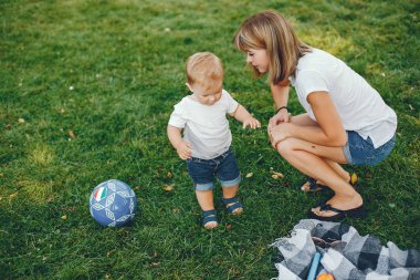 Anne ve oğlu yaz parkında oynuyorlar.