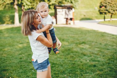 Anne ve oğlu yaz parkında oynuyorlar.