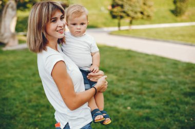 Anne ve oğlu yaz parkında oynuyorlar.
