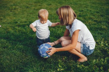 Anne ve oğlu yaz parkında oynuyorlar.