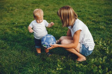 Anne ve oğlu yaz parkında oynuyorlar.