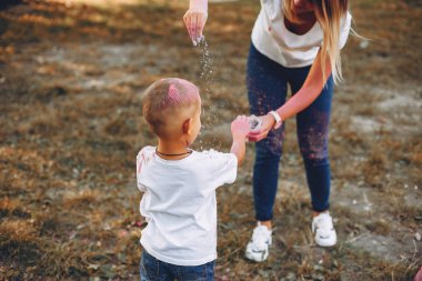 Anne ve oğlu yaz parkında oynuyorlar.