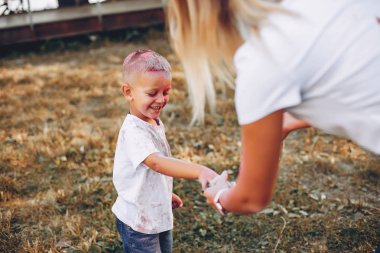 Anne ve oğlu yaz parkında oynuyorlar.