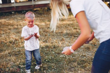 Anne ve oğlu yaz parkında oynuyorlar.