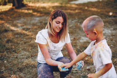 Anne ve oğlu yaz parkında oynuyorlar.