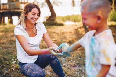 Anne ve oğlu yaz parkında oynuyorlar.