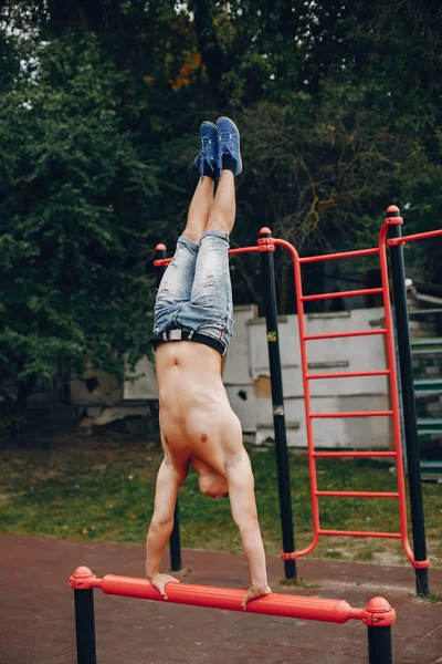 Handsome man training in a summer park — Stock Photo, Image