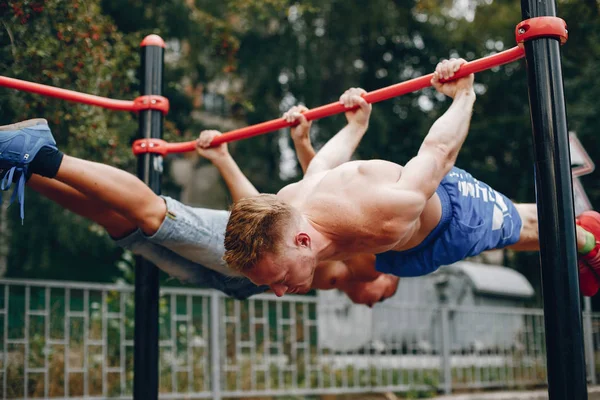 Dos hombres guapos entrenando en un parque de verano —  Fotos de Stock