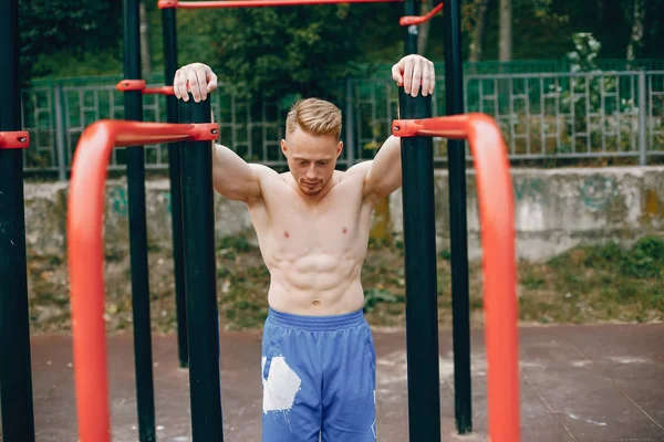 Hombre guapo entrenando en un parque de verano — Foto de Stock