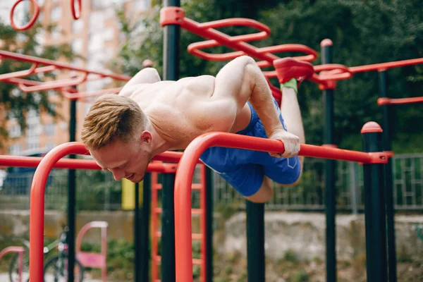 Snygg man utbildning i en sommarpark — Stockfoto