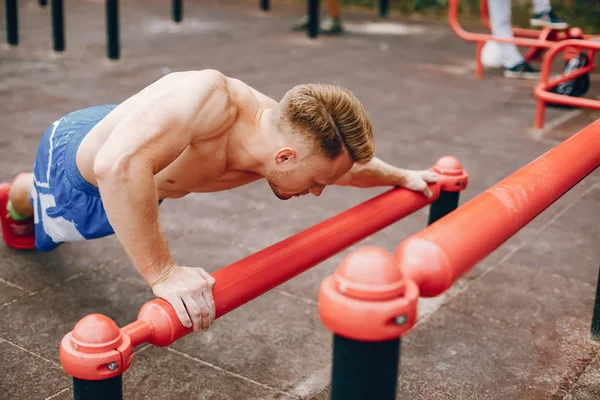 Bell'uomo che si allena in un parco estivo — Foto Stock