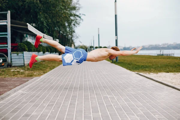 Bell'uomo che si allena in un parco estivo — Foto Stock